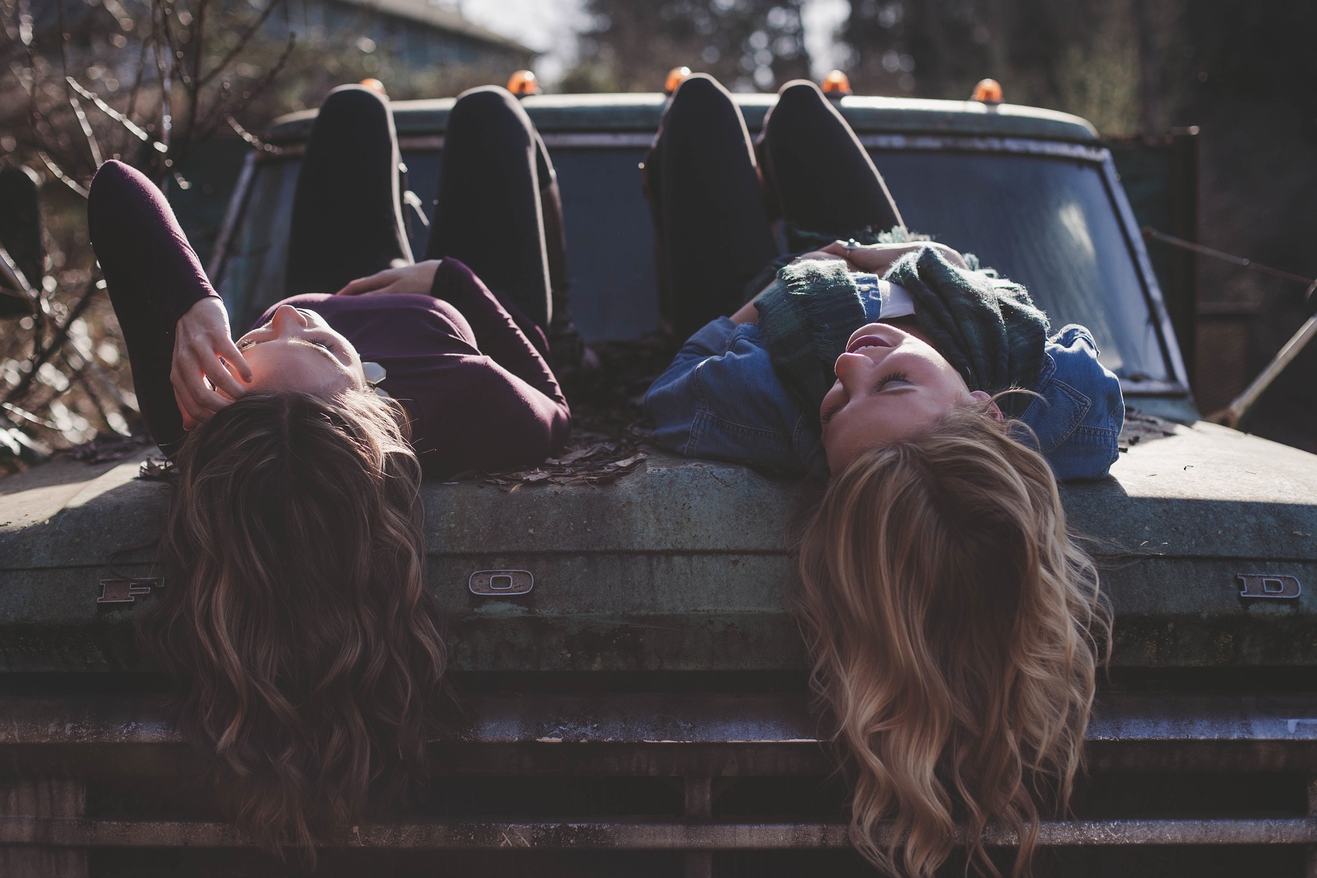 İki tane genç kız bir arabanın bagaj kapağına yatmış sohbet ediyorlar.