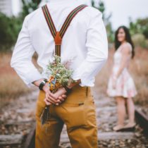 Adam, kadına sürpriz yapmak için arkasında bir demet çiçek gizliyor