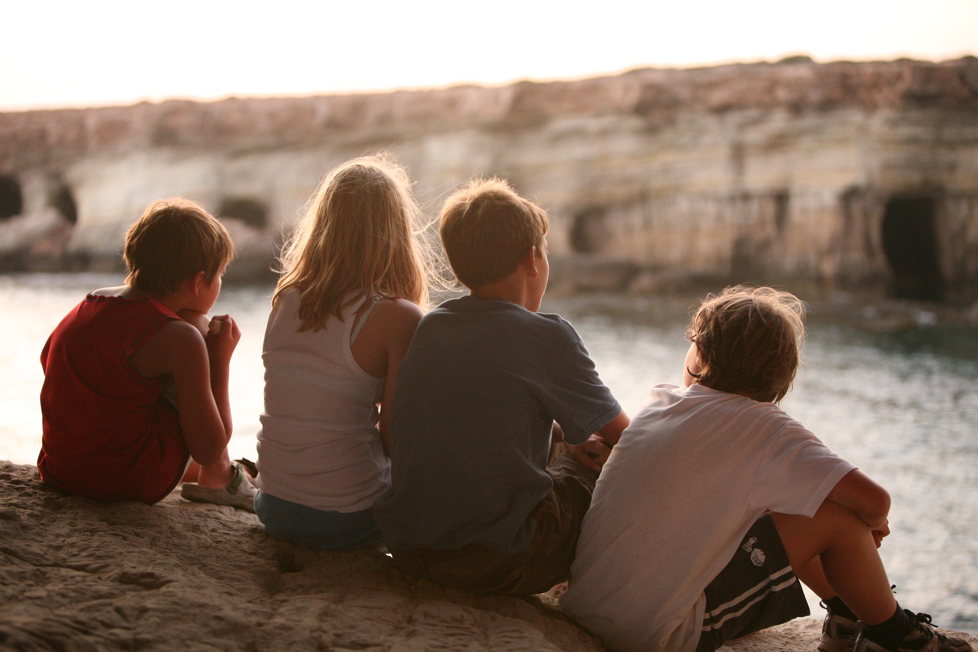 Biri kız dört çocuk toplanmış nehri izliyorlar.