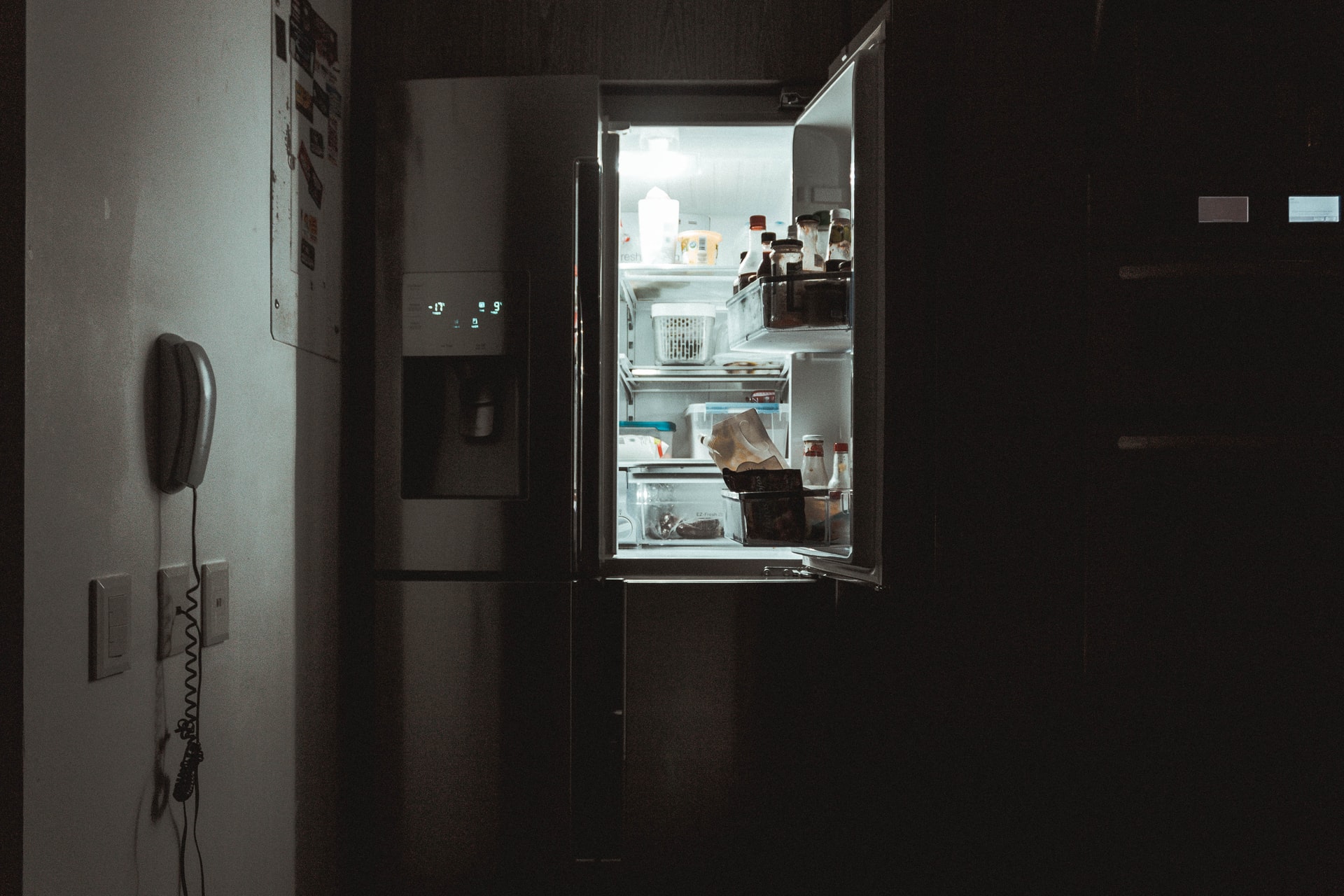 Kapağı açık buz dolabı karanlık mutfağı aydınlatıyor.
