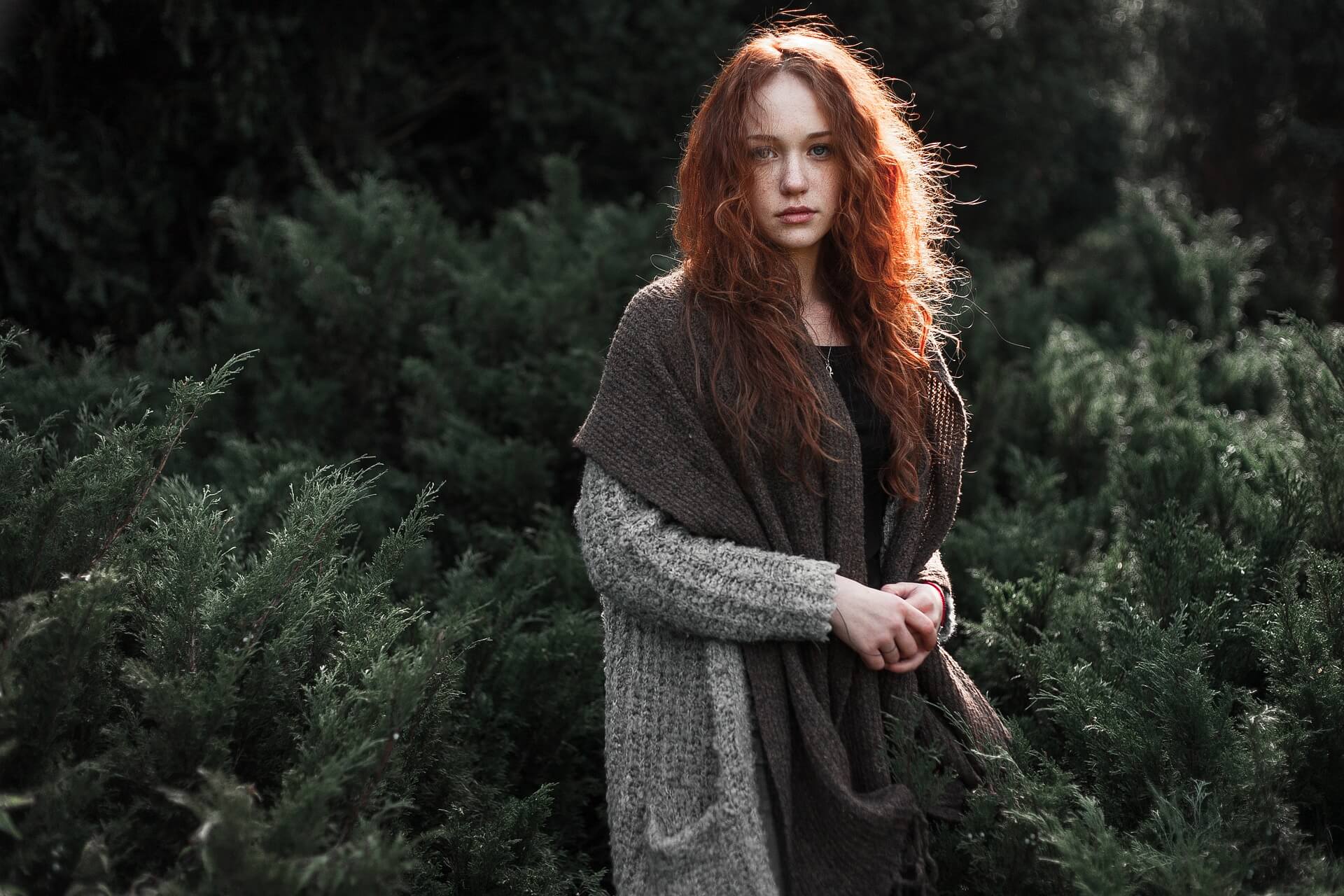 Kızıl saçlı bir kız ormanda geziyor.