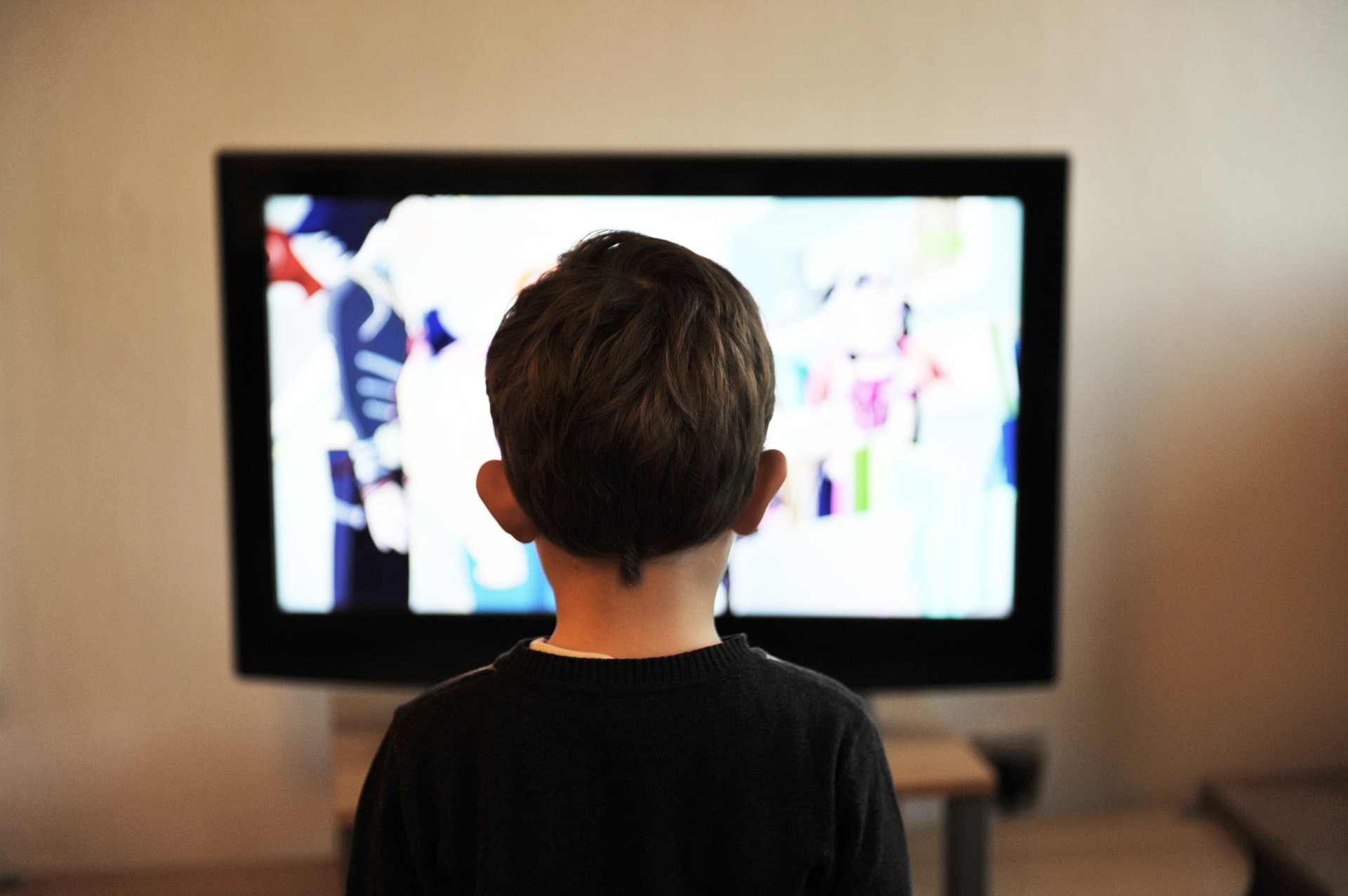 Bir çocuk, gözünü ayırmadan televizyon izliyor.