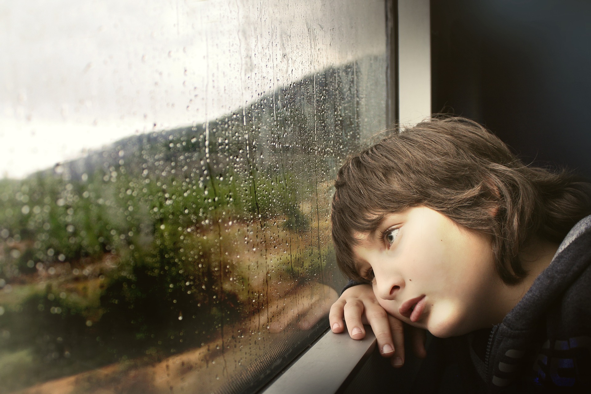 Bir çocuk trenin camından dışarı bakıyor.